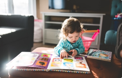 Baby reading a children's book in the living room