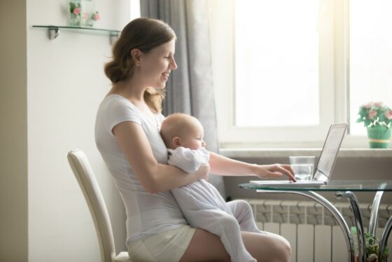 Mum on computer with baby on lap