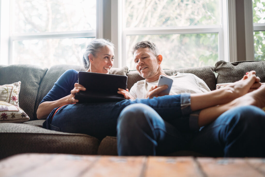 Mature Couple Relaxing with Tablet and Smartphone