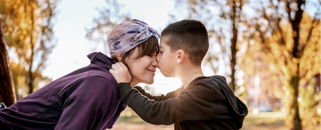 Mother and son embrace while walking in nature.