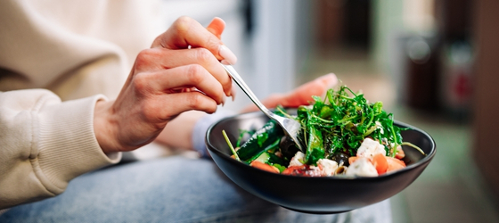 Close up hands holding a bowl of food