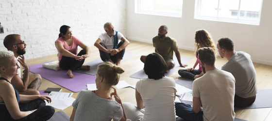 A group of people sitting in a circle on the ground
