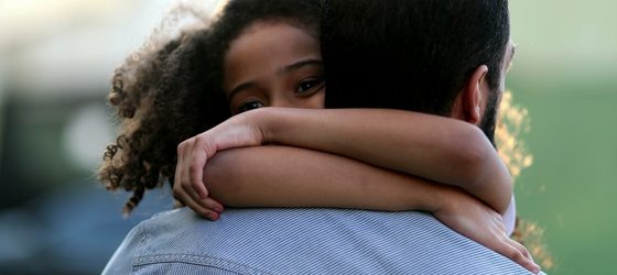 Close up image of a father and daughter embracing