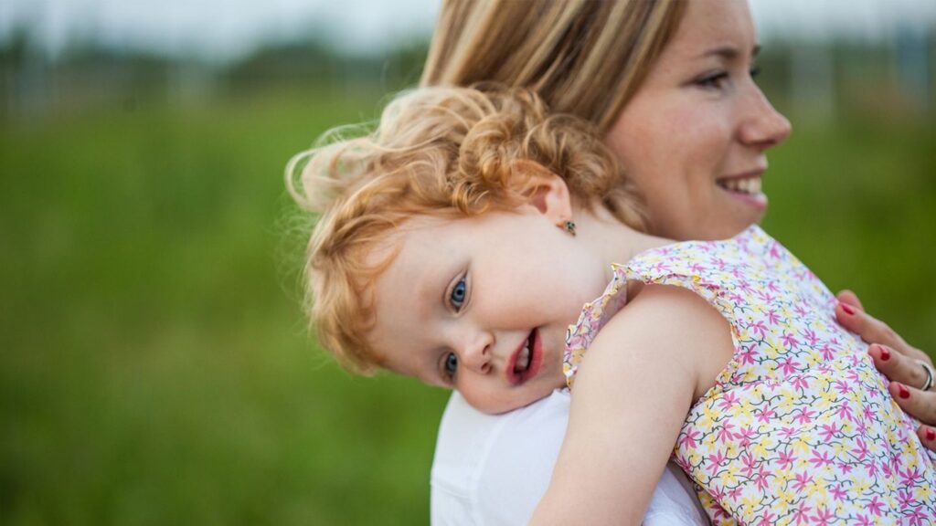 Toddler in flowered dress being carried