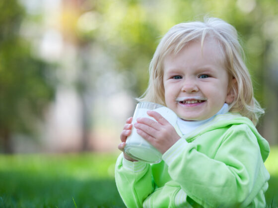 Smiling child drinking milk