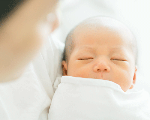 A mother holder her baby top baby names 2020 Karicare