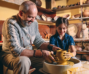 A grandfather and grandchild doing pottery